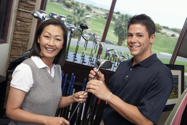Woman and man selecting golf club